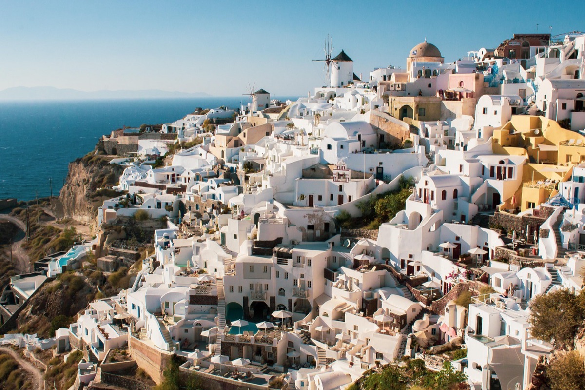 Santorini Sunset Over Caldera: Golden Light Reflects on Blue Waters