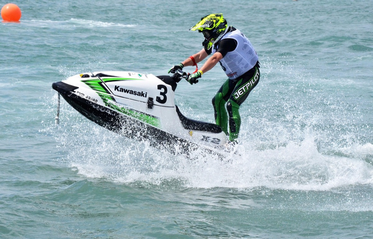 Un uomo incastrato in un jet-ski che attraversa il caldera di Santorini