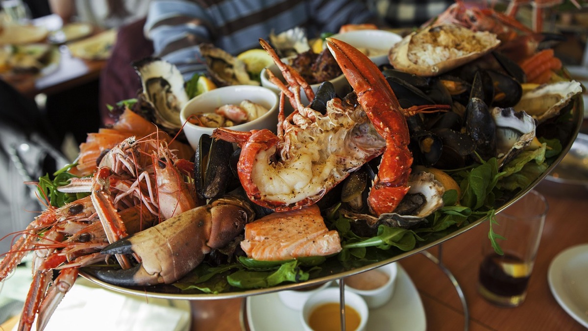 Local Santorini fisherman with seafood platter on a wooden board