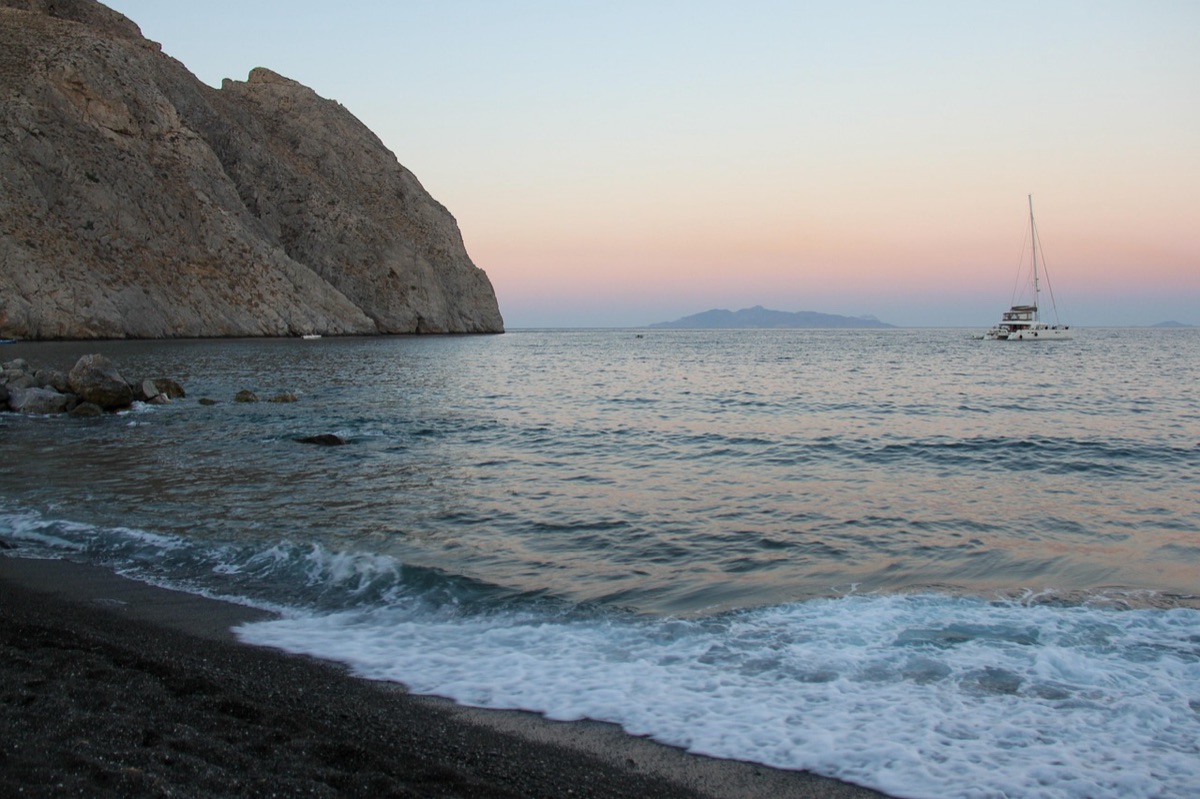 Santorini white sand beach with olive trees