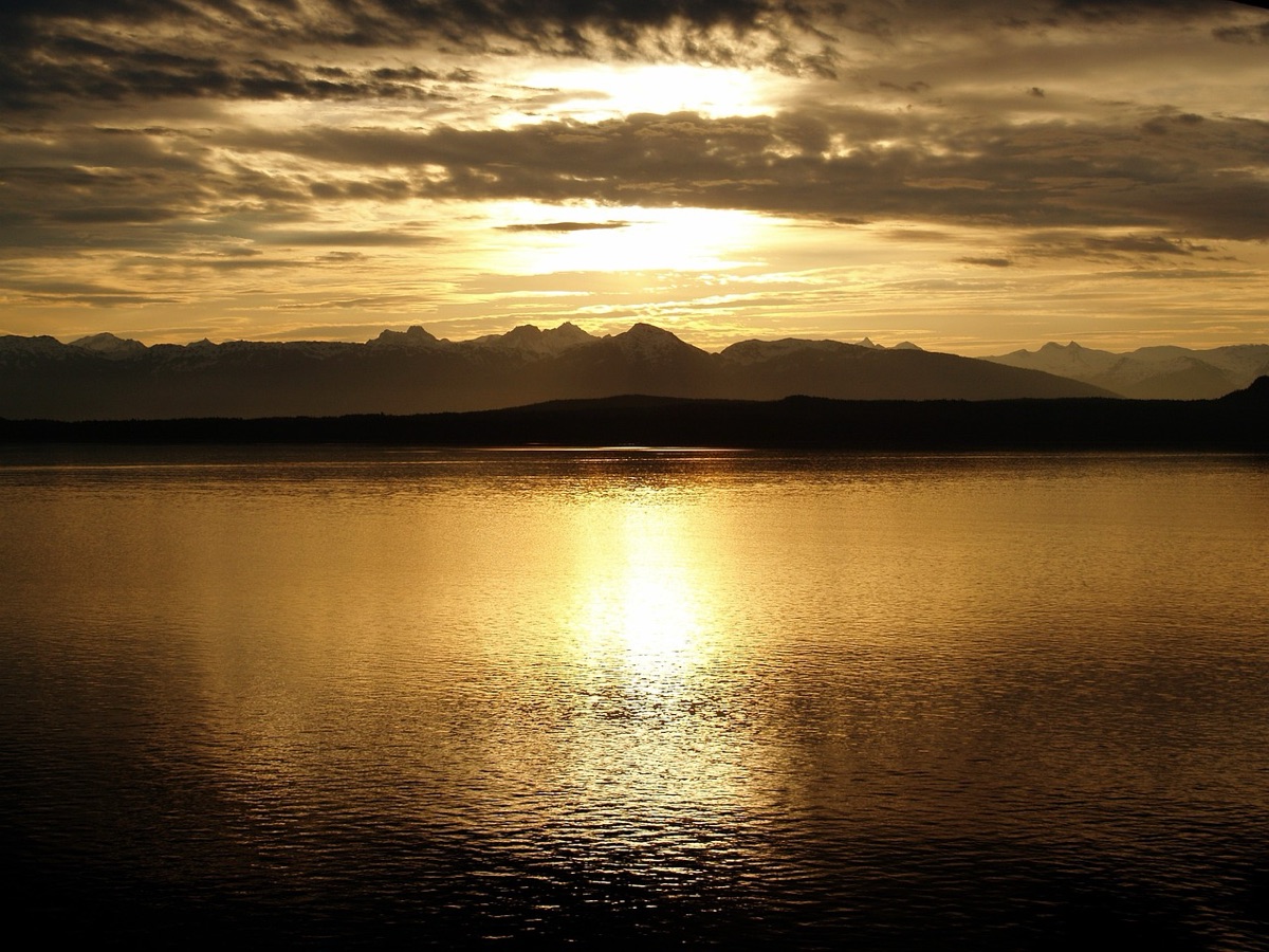 Sunset over ocean with distant mountains