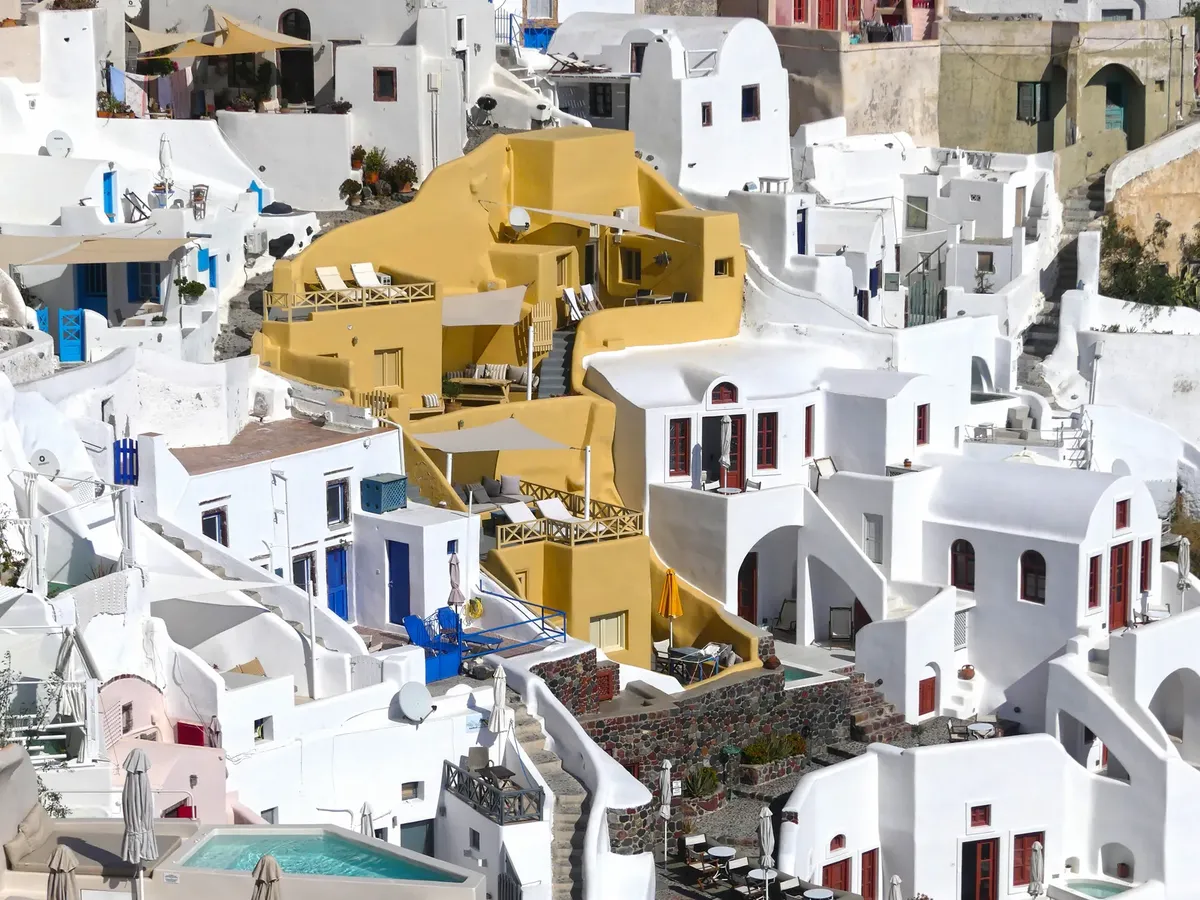 A stunning aerial view of Fira's whitewashed architecture on a sunny day in Santorini, Greece.