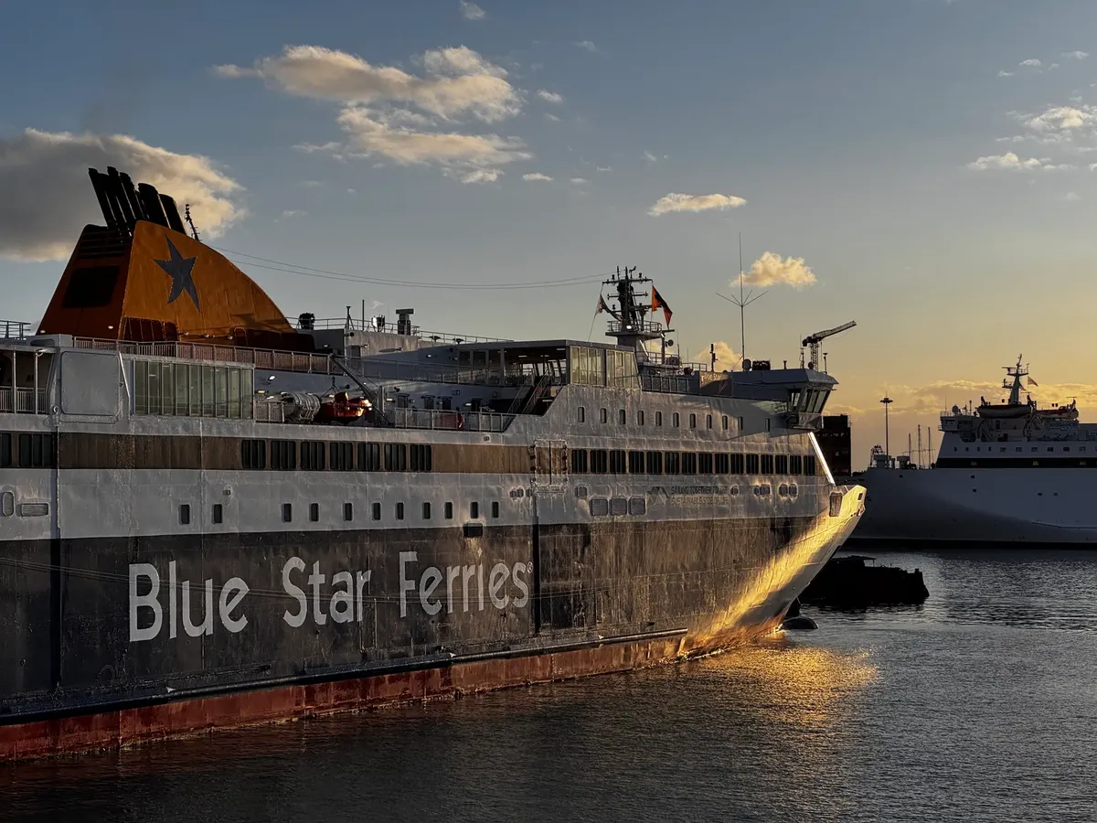 Beautiful view of a Blue Star Ferry docked in Athens, Greece at sunset, highlighting the tranquil scene.